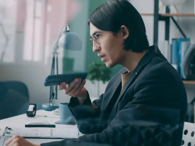 Marketer reviewing campaign data on a phone and laptop