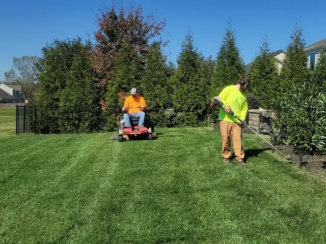 Landscaping crew mowing a residential lawn